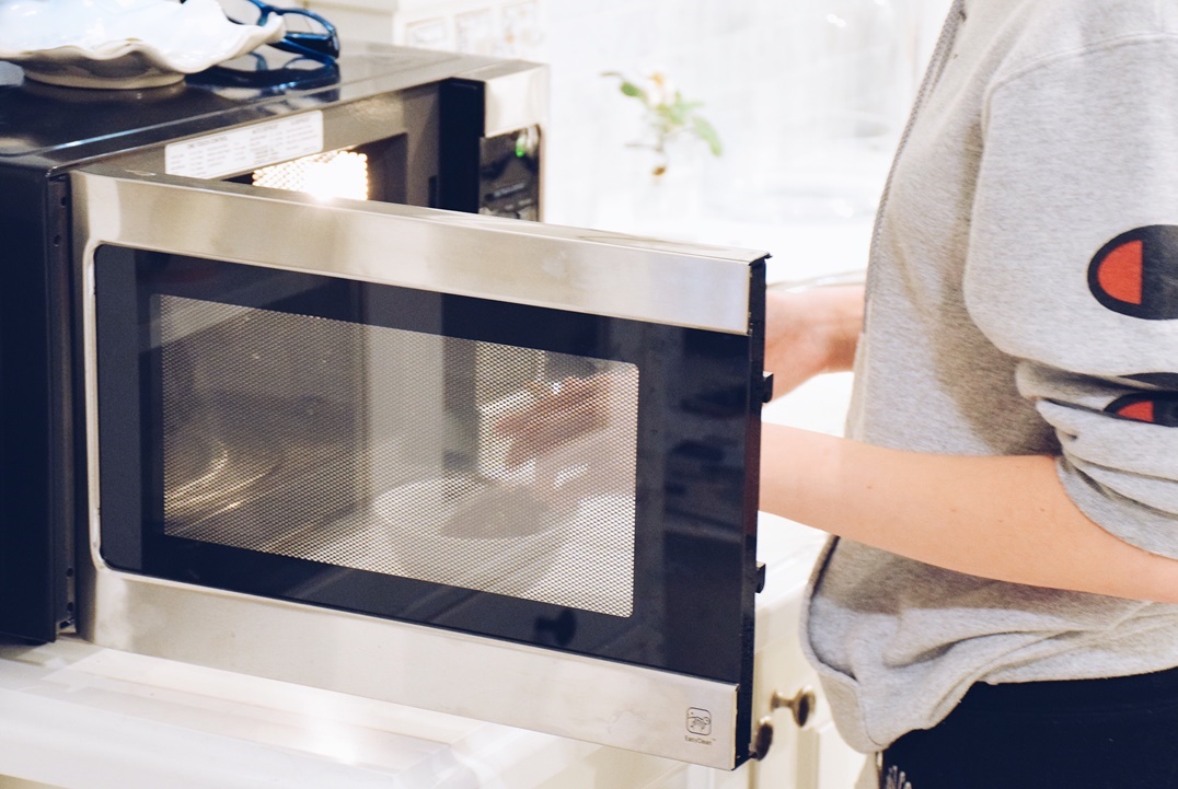 teenage-girl-using-microwave-oven-in-a-kitchen-at-2021-08-30-07-01-27-utc