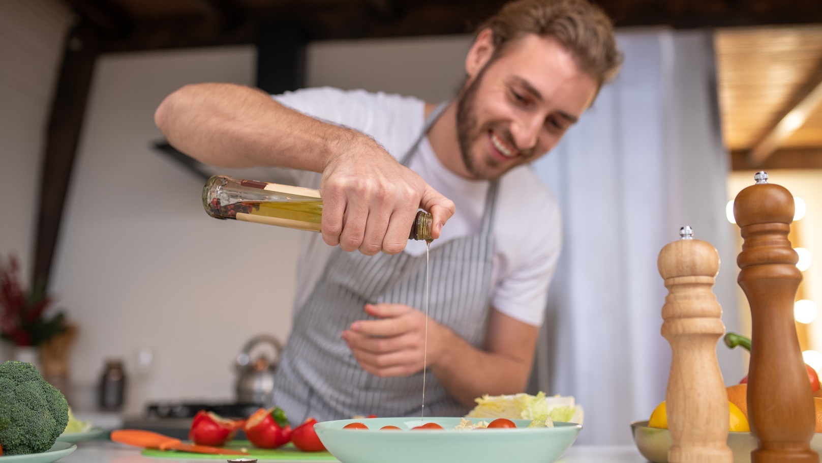 concentrated-cook-putting-some-oil-into-a-salad-2021-09-04-06-52-21-utc