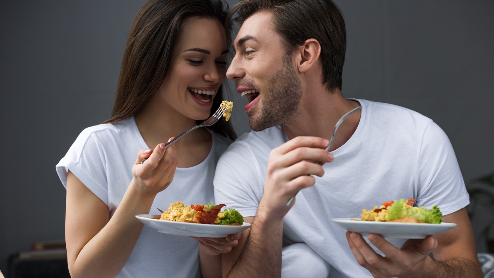 attractive-couple-eating-scrambled-eggs-in-bed-2021-09-02-03-22-54-utc