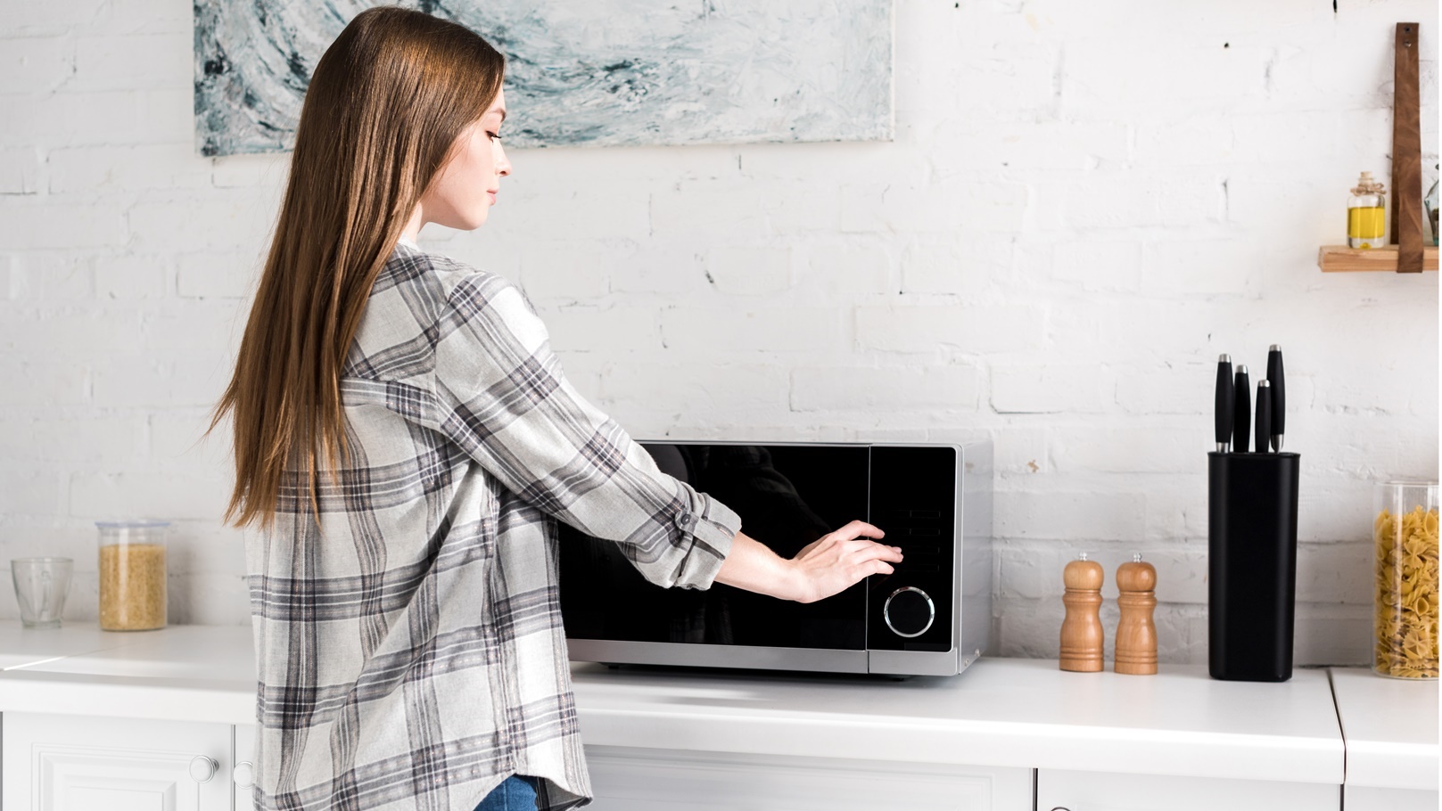 side-view-of-attractive-woman-using-microwave-in-k-2022-12-16-16-55-05-utc