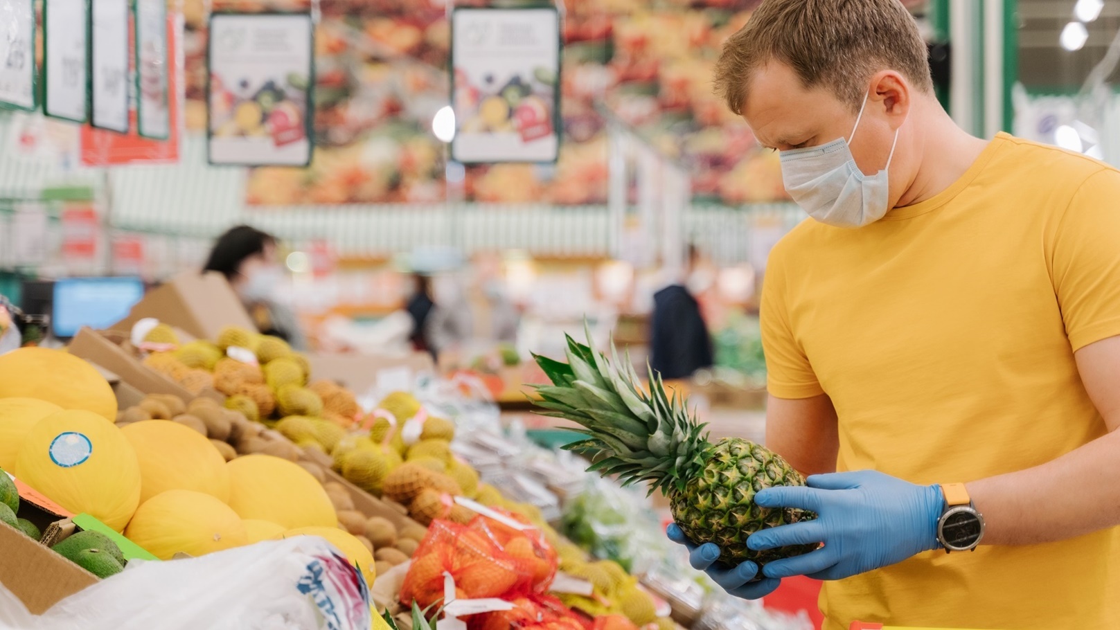 man-selects-pineapple-in-store-wears-medical-mask-2021-10-21-03-37-29-utc